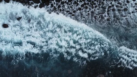 Top Down Aerial View of Ocean Waves Hitting Rocky Coastline Stock Footage 320734158