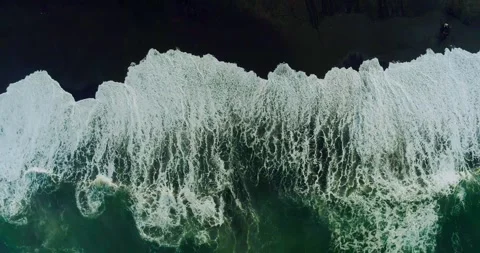 Top down aerial view of ocean waves crashing on tropical rocky shoreline Stock Footage 329461339