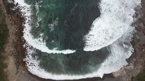 Top down aerial view of ocean waves crashing in rocky bay Stock Footage 336023046
