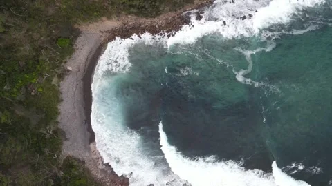 Top down aerial view of ocean waves crashing in rocky bay Stock Footage 336023051