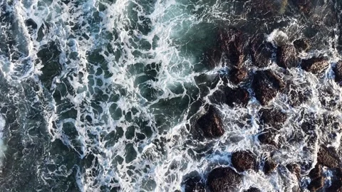 Top Down Aerial View of Ocean Waves Crashing over Coastal Rocks Stock Footage 344778143