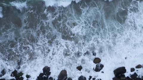 Top Down Aerial View of Ocean Storm Waves Crashing on Rocks Видео 347067975