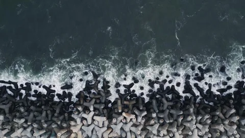 Top Down Aerial View of Ocean Waves Crashing on Concrete Breakwater Stockbeeldmateriaal 347068160