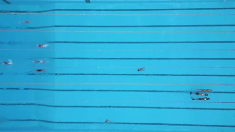 Top-down aerial view of outdoor swimming pool with swimmers moving along lanes. Stock-Footage 325741346