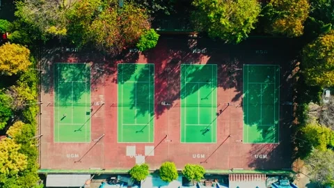 Top down aerial view of outdoor tennis courts surrounded by trees Stock Footage 342587839