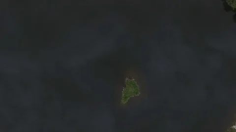 Top down aerial view over tiny island in reflective lake Vídeos de archivo 80357928