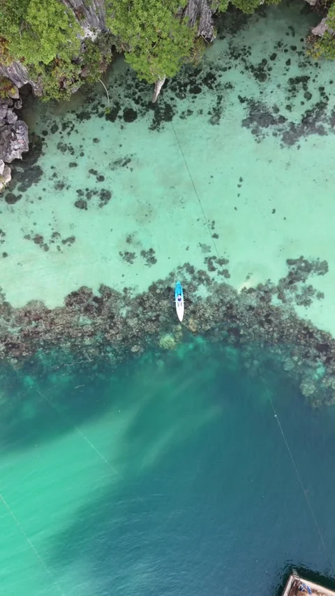 Top down aerial view of person in kayak above coral reef in Philippines Stock Footage 342348302