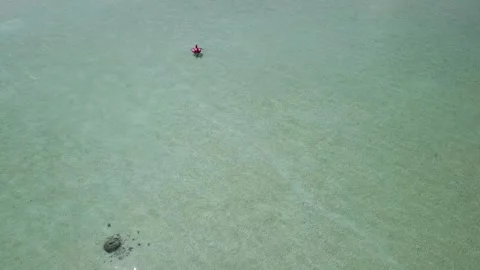 Top down aerial view of person floating on pink inflatable in Maldives 4K Vídeo Stock 342431639