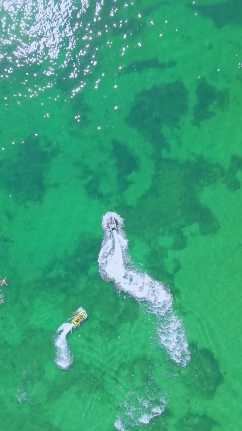 Top-Down Aerial View of personal waterfrafts on Emerald Green Ocean Видео 327911215