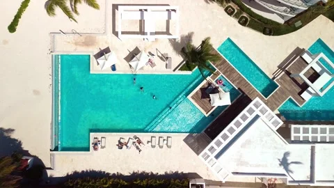 Top down aerial view of pool on grounds of a luxury hotel in tropics. Palm trees 스톡 동영상 274372351