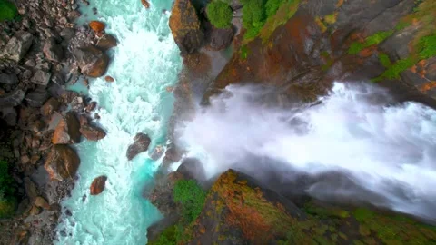 Top-Down Aerial View of a Powerful Waterfall Flowing into Turquoise River Stock-Footage 341211645