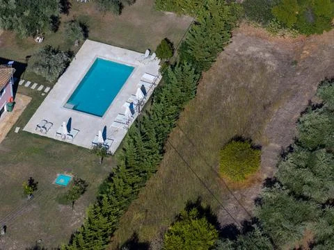 Top down aerial view of a private swimming pool with sun loungers parasols .. Foto stock