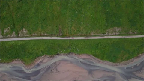 Top Down Aerial View Red Car in Iceland Drives on Road Next to River Braids.. Stock Footage 258486366