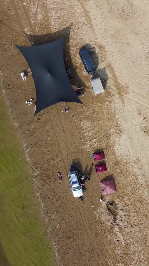 Top down aerial view of remote campsite with black tent and 4x4 cars Видео 336687944