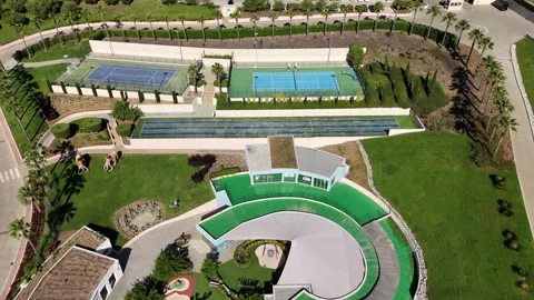 Top-down aerial view of resort sports area with tennis courts and green park Stock Footage 327662125