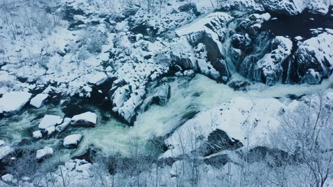 Top down aerial view of the river flow in a snow covered rocky area in winter. Stockbeeldmateriaal 145910005