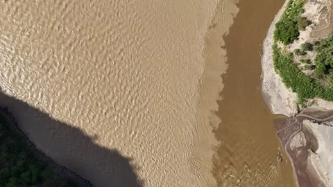 Top down aerial view of a river confluence mixing muddy and clear water dynamics Stockbeeldmateriaal 332945281