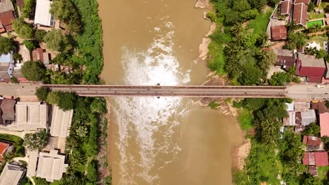 Top Down Aerial View of River Bridge, Rooftops and Palm Trees, Luang Prabang Stock-Footage 347422187