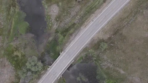 Top down aerial view of road running thru pasture Stock Footage 246840469