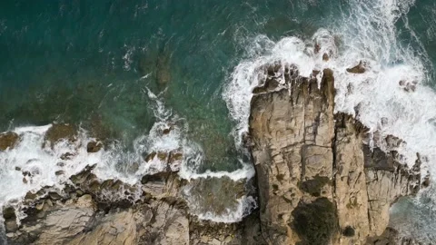 A top down aerial view of rocks and sea provides a stunning visual perspective Video stock 239073557