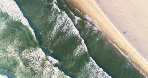 Top-down aerial view of rolling waves at the sandy beach. Drone video zenit.. Stock-Footage 294606140
