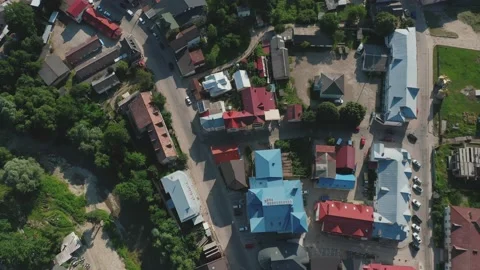 A top-down aerial view of the roofs of houses of a small town with a river Stock-Footage 181517509