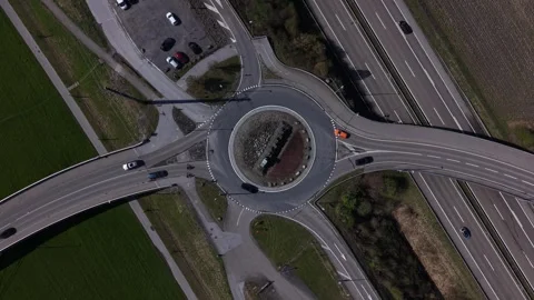 Top down aerial view of roundabout with cars and cyclists 動画素材 332247522