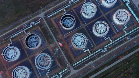A top-down aerial view of rows of oil tanks connected by pipes at a refinery. Stock Footage 167131558