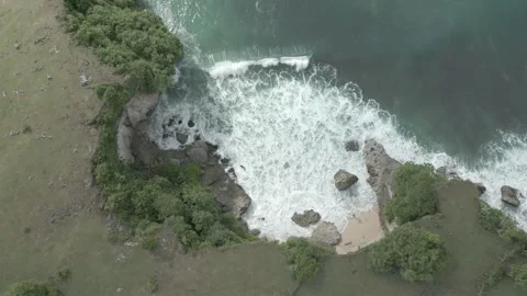 Top-Down Aerial View of Rugged Coastline and Crashing Waves on Cliffs Stock Footage 314368456