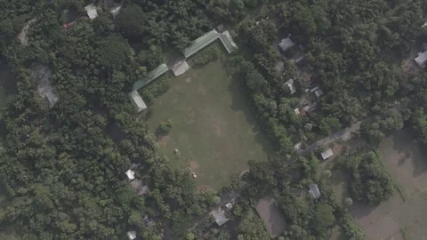 Top-Down Aerial View of a Rural Primary School Field Surrounded by Greenery Stock Footage 305874143