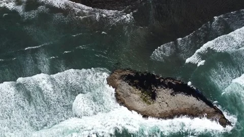 Top-Down Aerial View of Sea Waves Crashing Around a Large Rock Stock Footage 317470308
