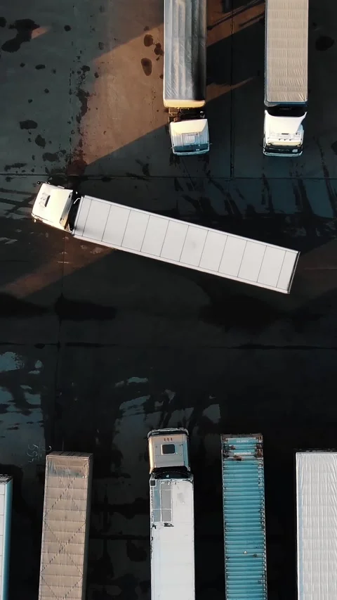 Top down aerial view of a semi trailer truck maneuvering and reversing into a Stock Footage 345959938