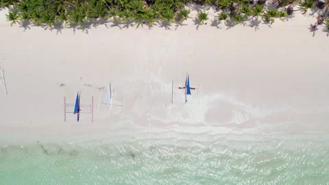 Top-Down Aerial View of Serene Tropical Beach with Blue Sailing Canoe Stock Footage 262104460