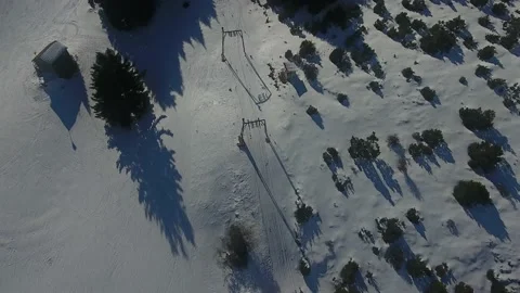 Top down aerial view of ski lifts on a snowy mountain slope Stockbeeldmateriaal 217394529