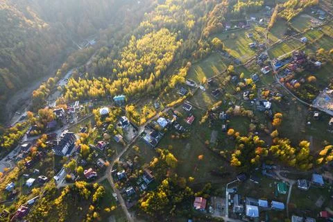 Top down aerial view of the small village between mountains in autumn. Stock Photos
