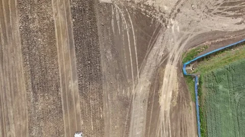 Top down aerial view of soil compactor operating on graded logistics platform Stock Footage 336257114