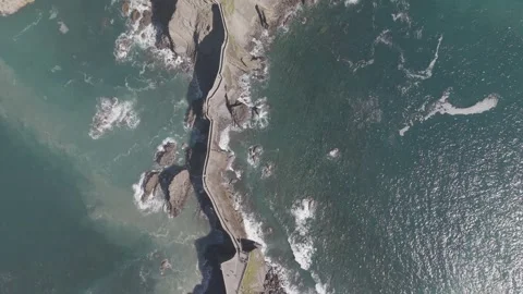 Top down aerial view of a stone causeway leading to a rocky island Vídeos de archivo 342261511