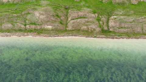 Top down aerial view of surrealistic terrain with hills near calm green water Stock Footage 164680268