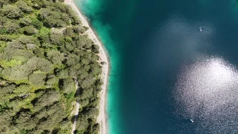 Top down aerial view traces the forested edge of Blindsee in the Austrian Tyrol Vídeo Stock 347128847