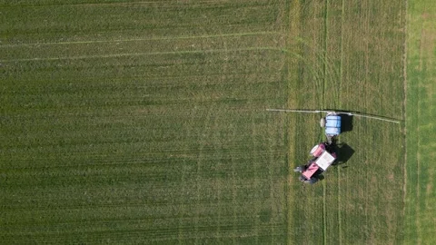 Top Down Aerial View of Tractor Spraying Fertilizer on Green Field Video stock 331929124