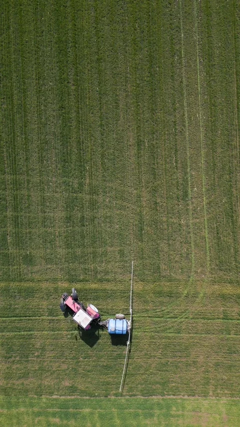 Top Down Aerial View of Tractor Spraying Fertilizer on Green Field Stock Footage 331929130