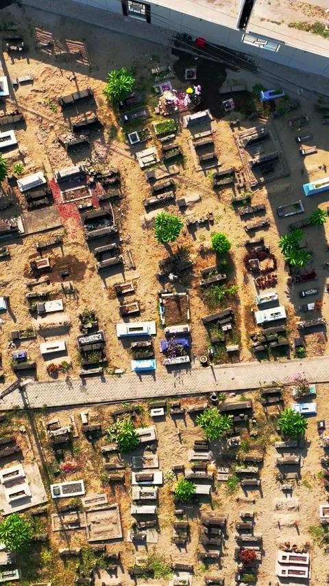 Top down aerial view of traditional graveyard beside an urban roadway Stock Footage 346740974