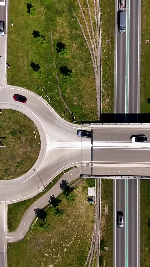 Top-down aerial view of traffic on highway overpass and roundabout 스톡 동영상 336496728