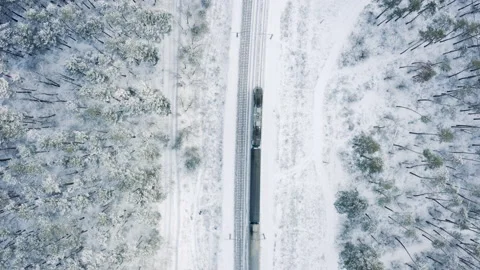 Top down aerial view of train travelling in the winter forest covered in snow. Stock Footage 147026795