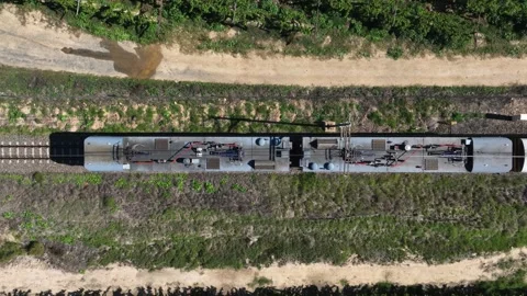 Top down aerial view of train rolling slowly on rural railway tracks Stock Footage 333633362