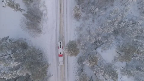 Top down aerial view of truck driving on snow covered forest road Stock Footage 325672108