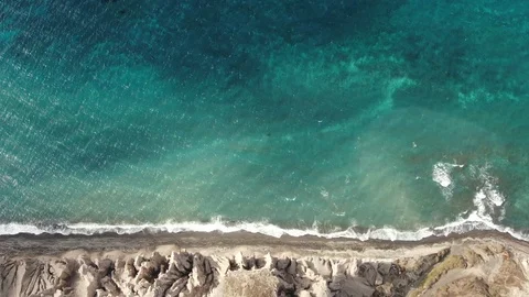 Top-down aerial view of turquoise blue ocean waves breaking on the shore of Video stock 121473516