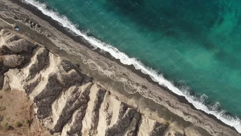 Top-down aerial view of turquoise blue ocean waves breaking on the shore of Vidéo 121473683