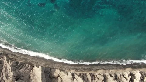 Top-down aerial view of turquoise blue ocean waves breaking on the shore of Stock Footage 145409475