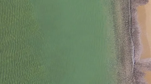 Top Down Aerial View of Turquoise Sea Waves and Sandy Shoreline Stock Footage 325292434